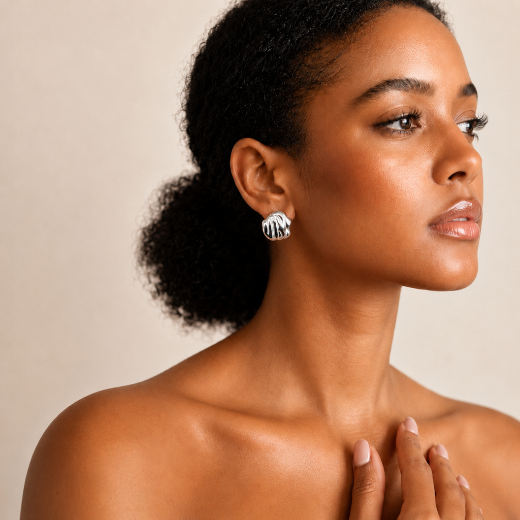 Mmírí Studs sculptural textured silver stud earrings with polished ripple detail worn by model against neutral background – hypoallergenic waterproof tarnish-free sterling silver earrings