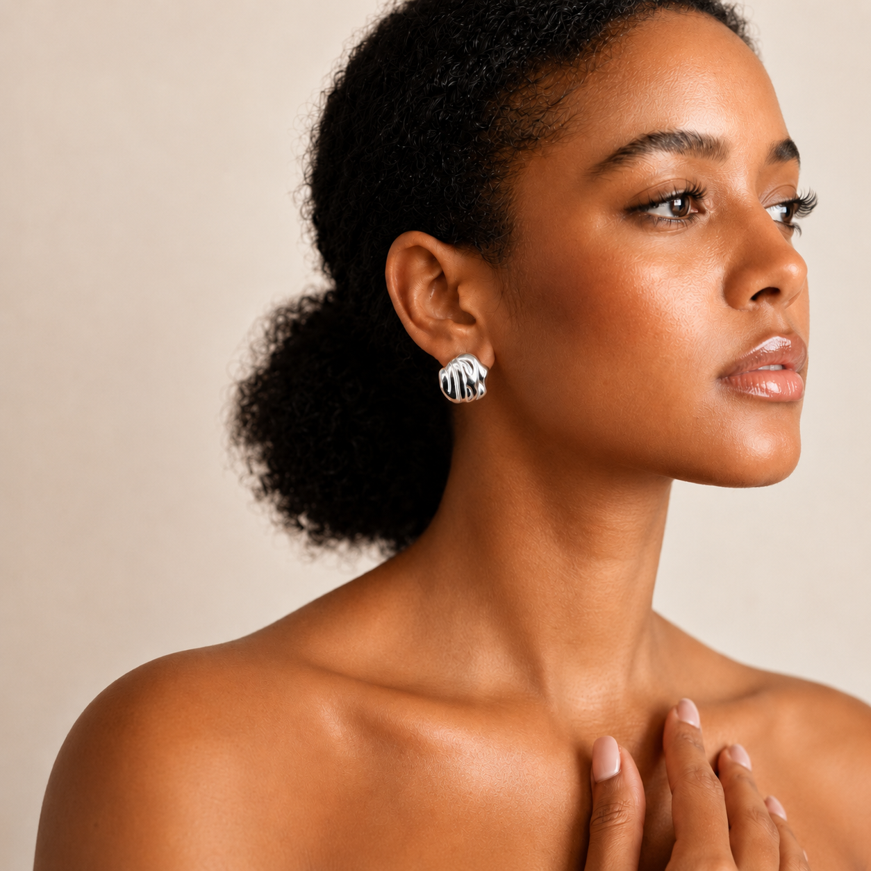 Mmírí Studs sculptural textured silver stud earrings with polished ripple detail worn by model against neutral background – hypoallergenic waterproof tarnish-free sterling silver earrings