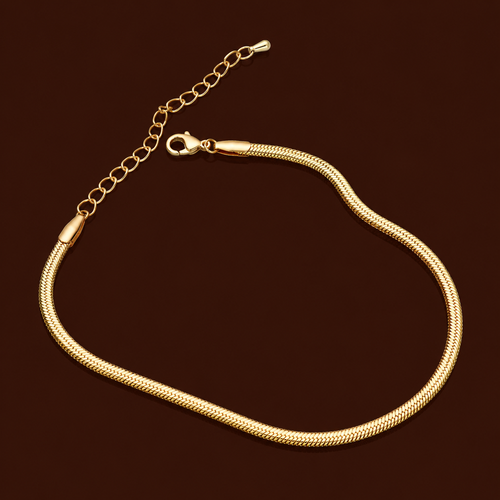 Ari Anklet gold snake chain herringbone anklet on dark background – minimal flat chain stainless steel anklet for women, non-tarnish and hypoallergenic