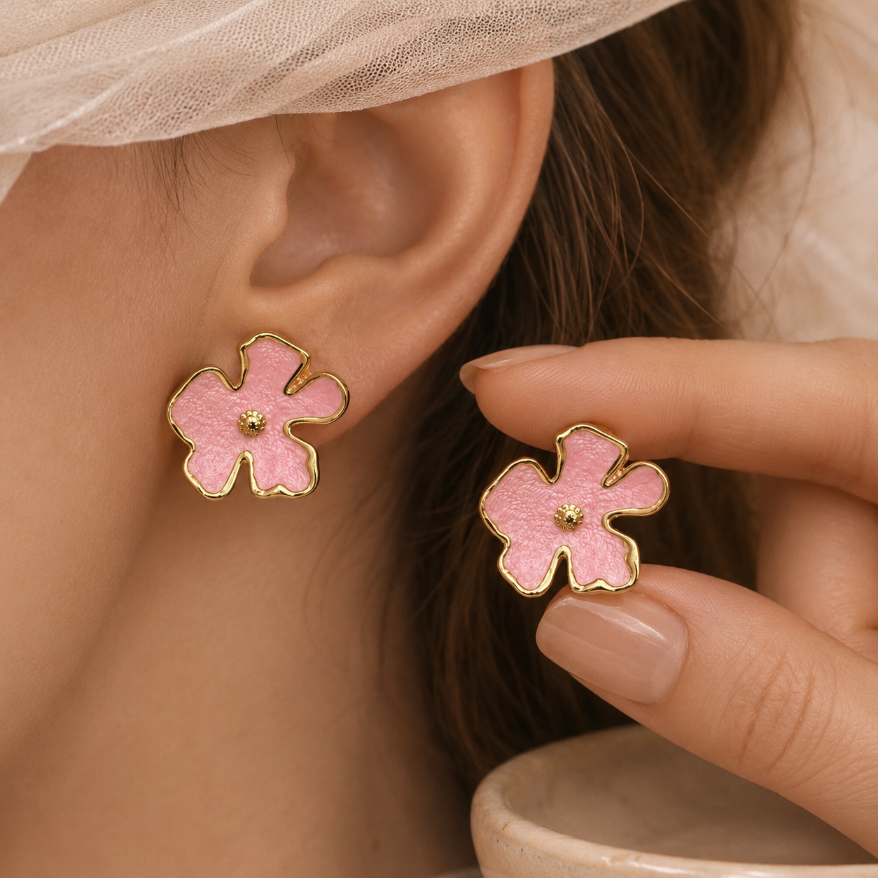 Bloomie Studs pink pastel enamel floral stud earrings worn and held by model – hypoallergenic non-tarnish nickel-free stainless steel flower stud earrings gift idea for women