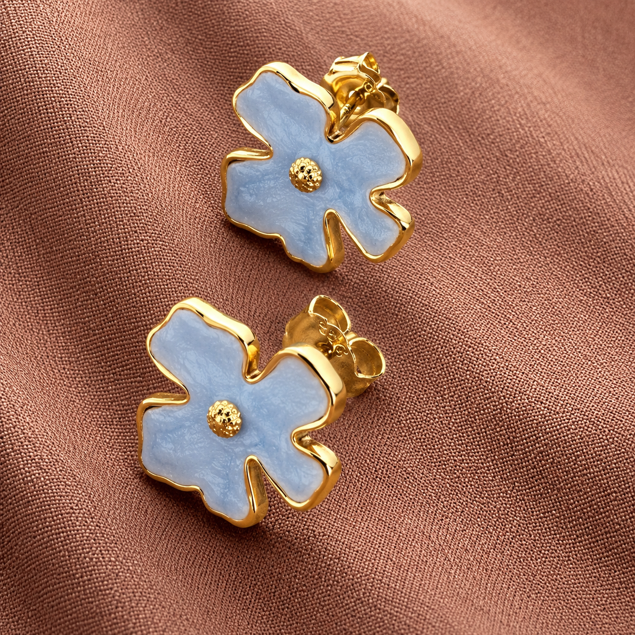 Bloomie Studs sky blue enamel flower stud earrings with gold wavy border and textured gold centre on warm fabric – hypoallergenic nickel-free non-allergic stainless steel floral stud earrings
