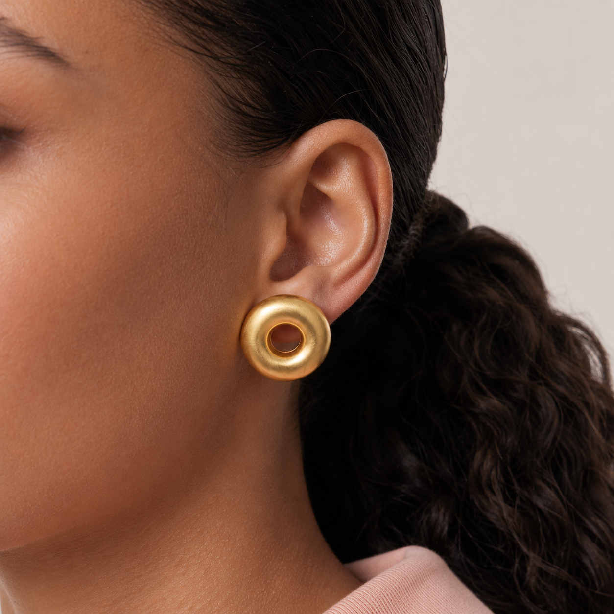 Model wearing Chọ Studs round gold donut stud earrings – minimalist earrings, hypoallergenic stud earrings, everyday stud earrings in brushed gold finish