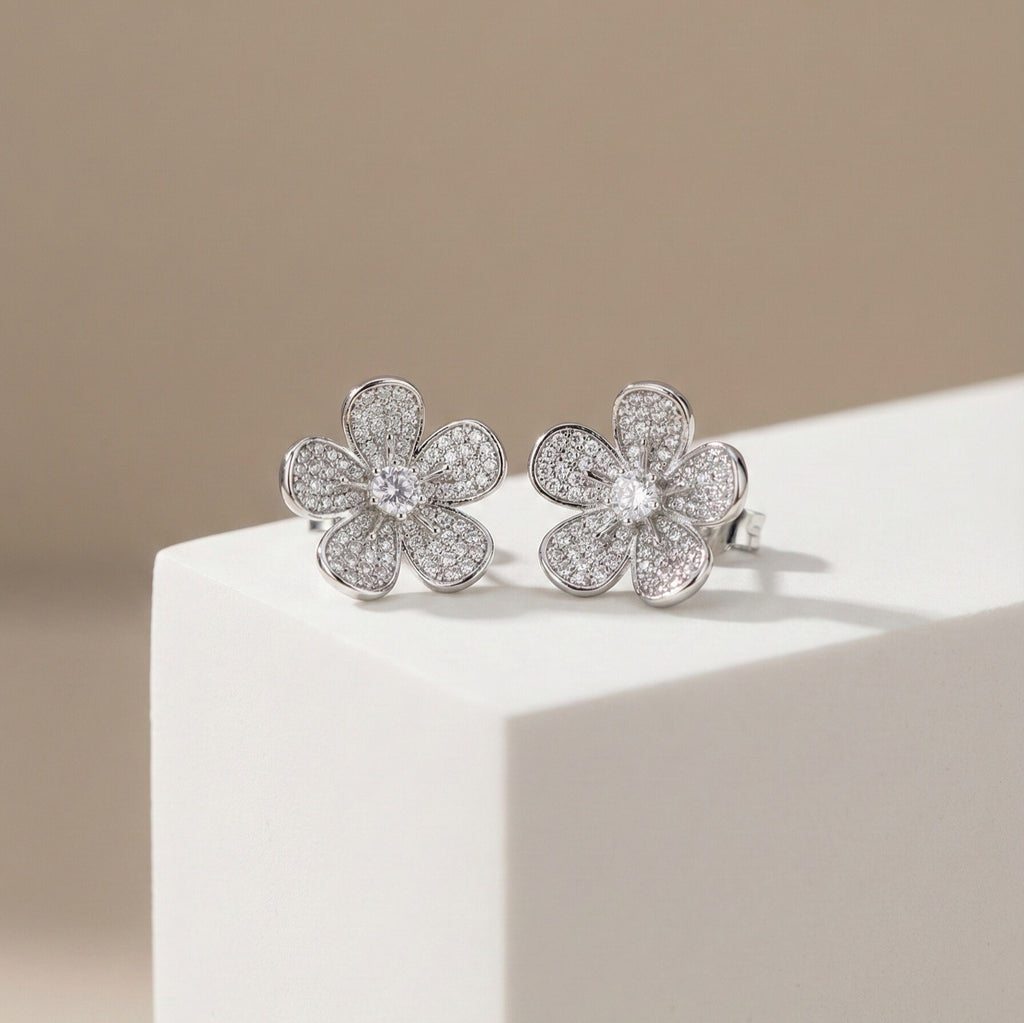 Daeze Studs silver pavé cubic zirconia flower stud earrings with CZ solitaire centre on white display block – surgical steel sparkle earrings for sensitive ears that don't tarnish