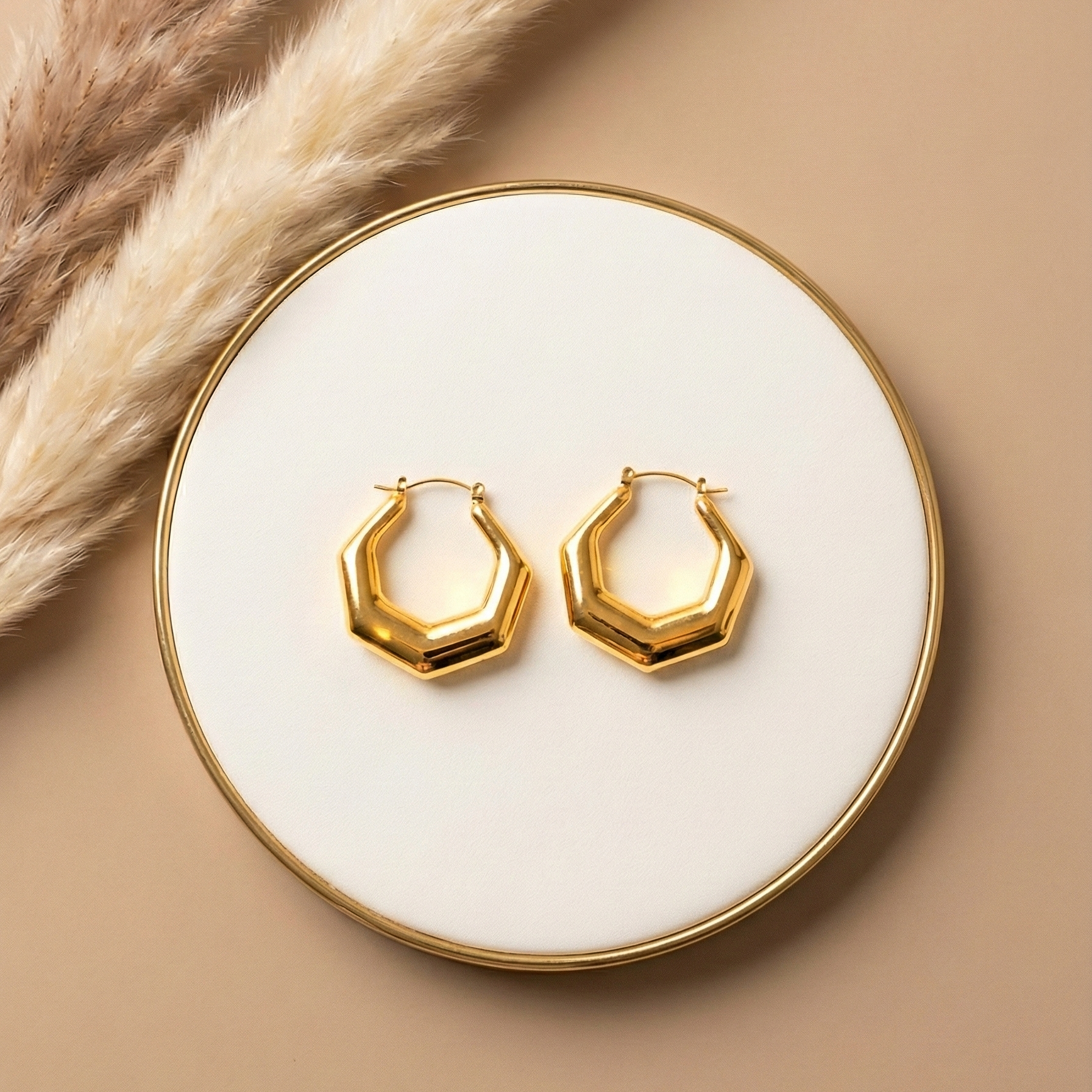 Hexa Hoops chunky gold hexagonal hoop earrings displayed on white plate with dried pampas grass – geometric angular stainless steel hoop earrings hypoallergenic