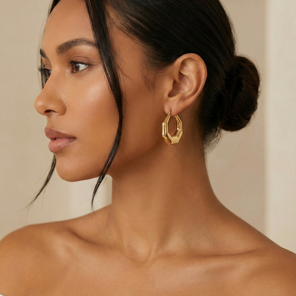 Hexa Hoops gold hexagonal hoop earrings worn by model with sleek low bun – geometric angular chunky gold hoops hypoallergenic stainless steel
