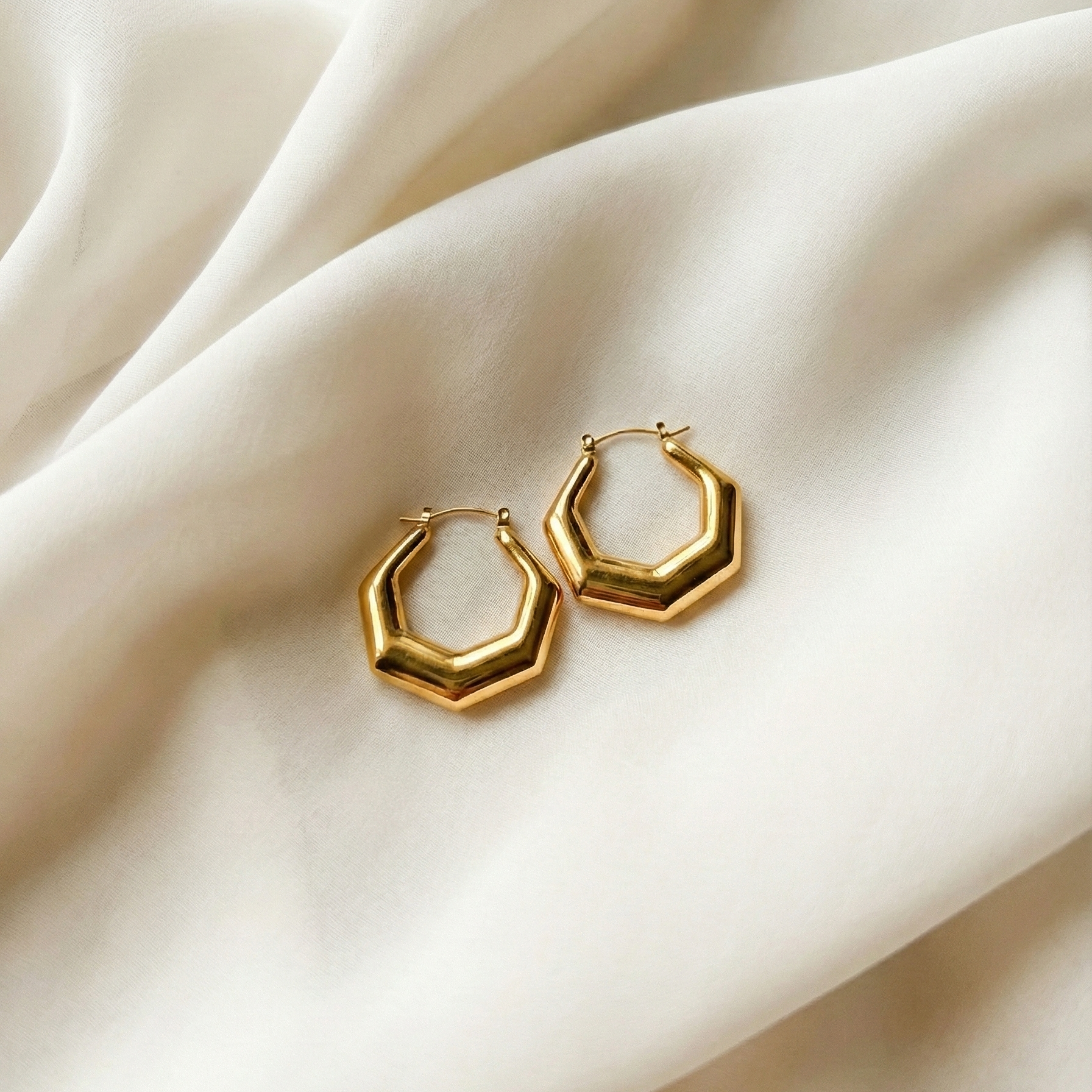 Hexa Hoops chunky gold hoop earrings with angular hexagonal silhouette on cream silk fabric – minimalist stainless steel hoop earrings non-tarnish waterproof