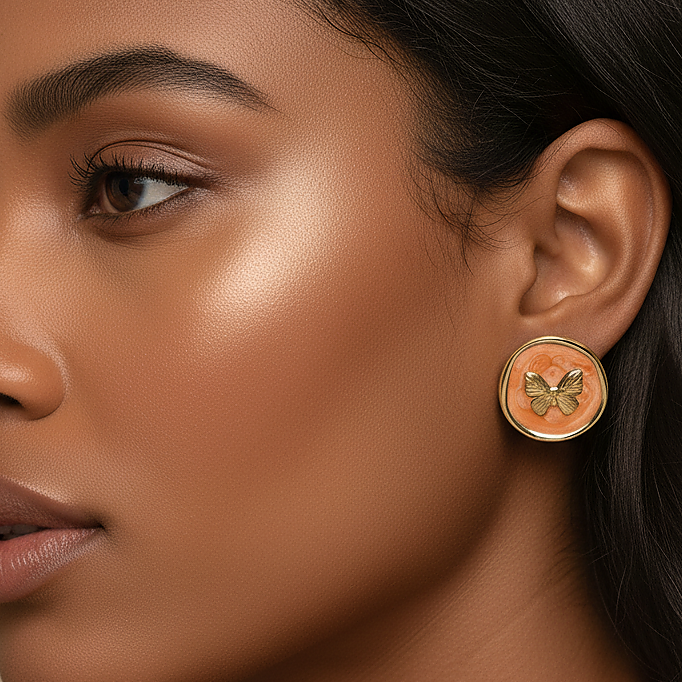 Kora Studs peach enamel butterfly earrings with gold butterfly charm worn by model – hypoallergenic stud earrings for sensitive ears