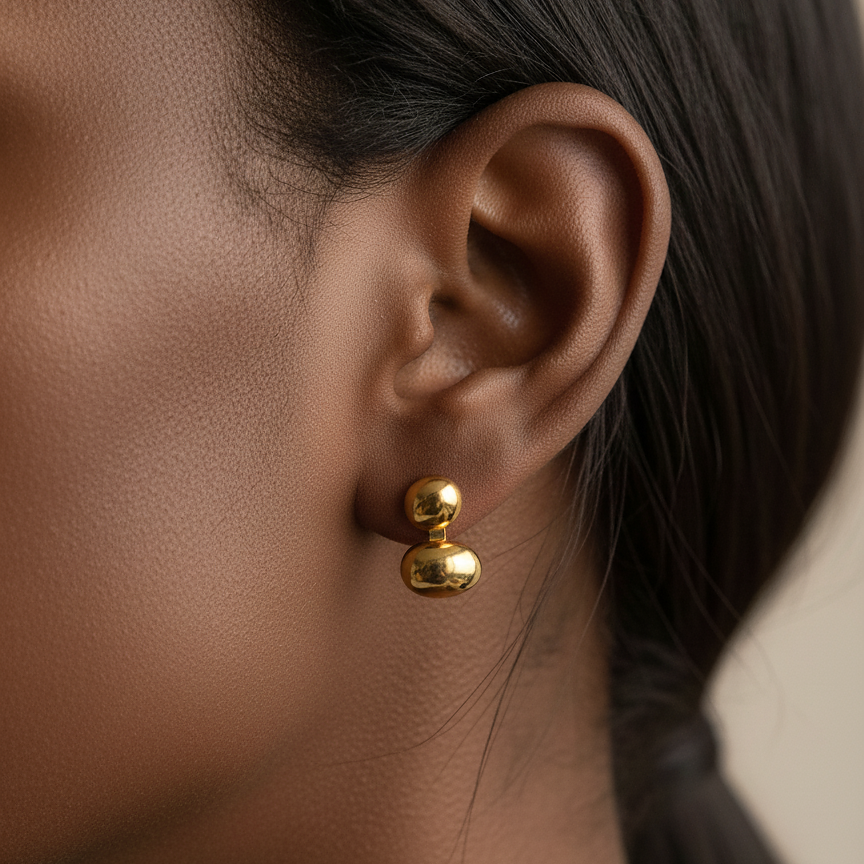 Lea Studs gold stacked bean drop stud earrings worn on ear in editorial side profile – minimalist stainless steel stud earrings, tarnish free and water resistant for everyday wear