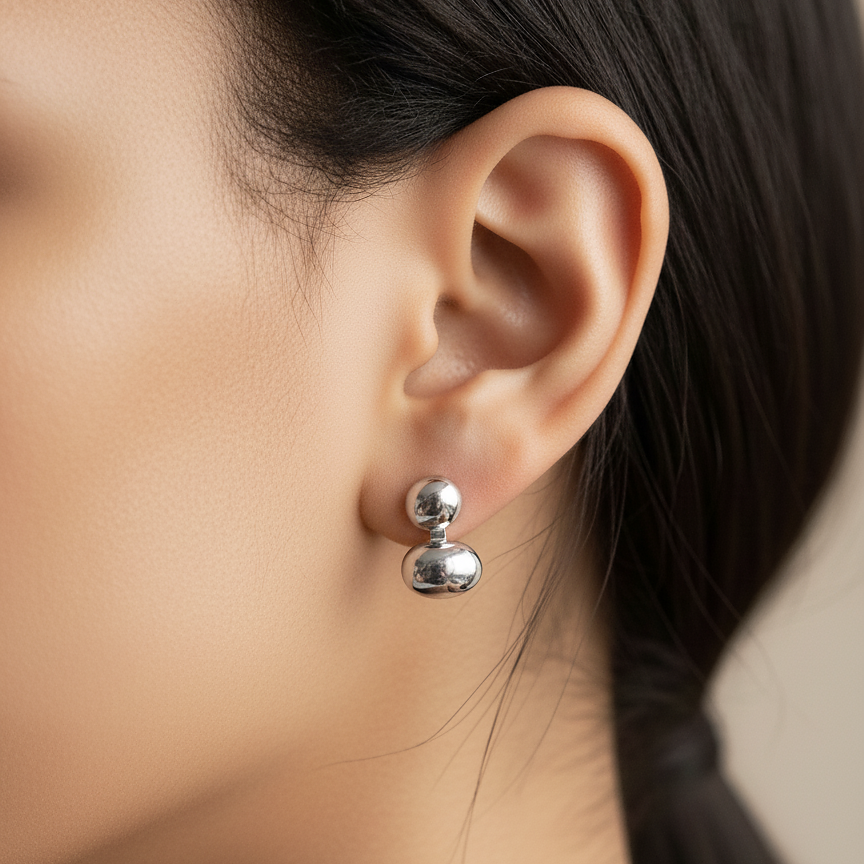 Lea Studs silver stacked bean drop stud earrings worn on ear of model with sleek black hair – minimalist gold and silver earrings in hypoallergenic stainless steel for sensitive ears