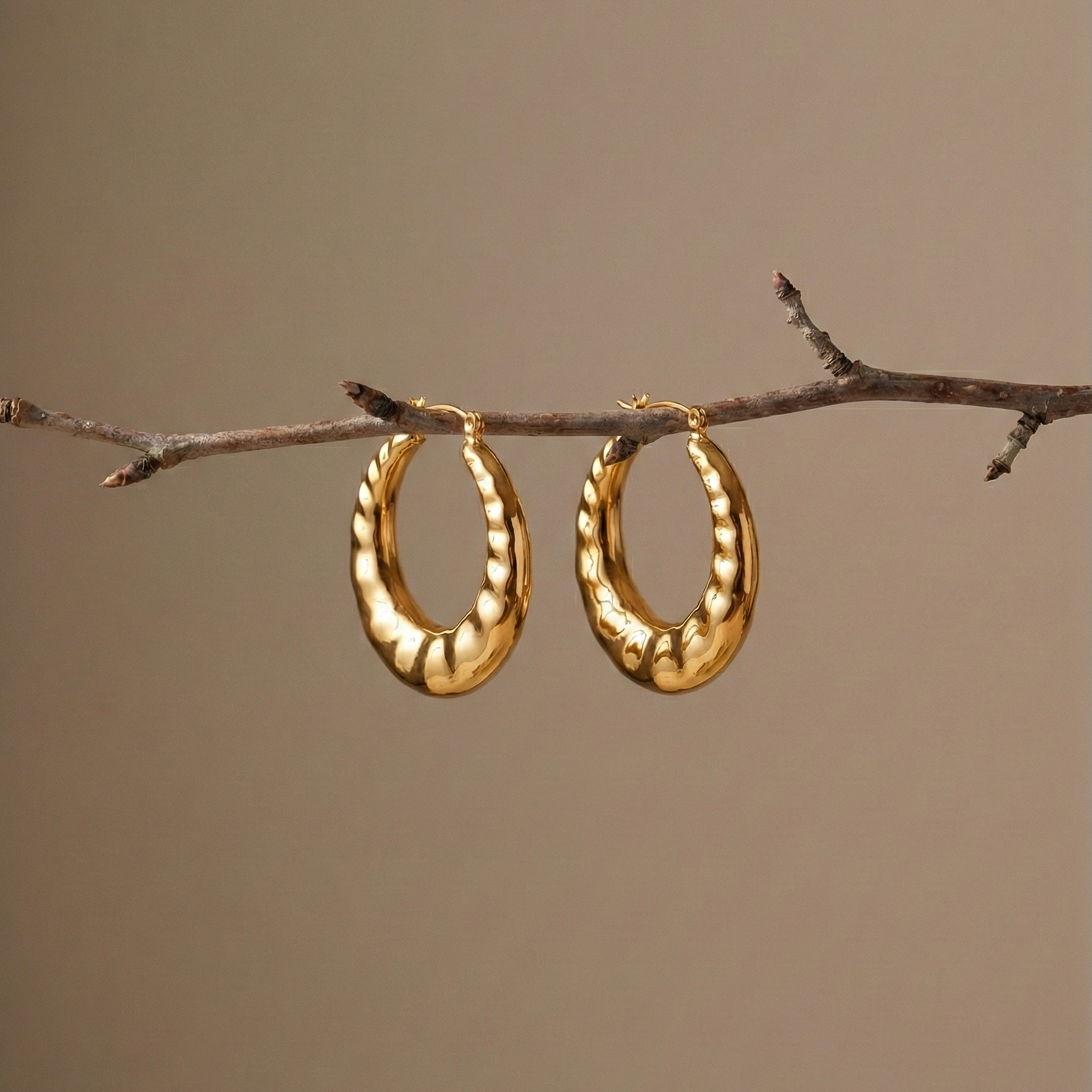 Lúlú Hoops chunky hoop earrings with bamboo earrings texture, hanging from a natural tree branch – bamboo hoop earrings, hypoallergenic hoop earrings in gold finish