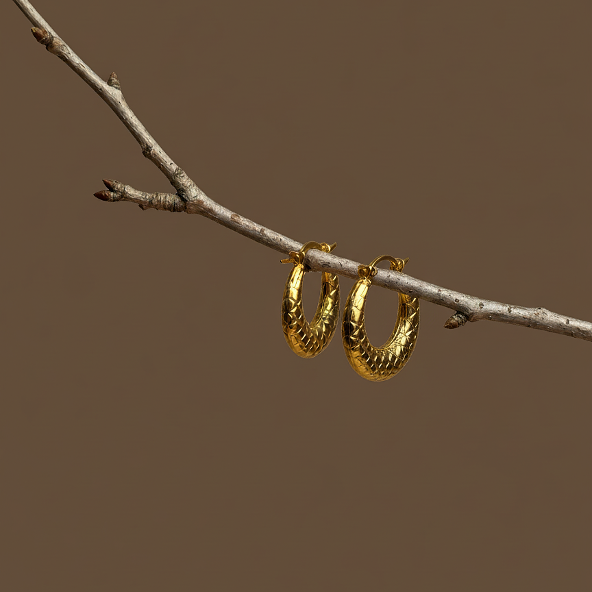 Mara Hoops quilted earrings hanging from natural tree branch – textured earrings in crescent hoop earrings silhouette, chunky earrings in gold hoop earrings finish