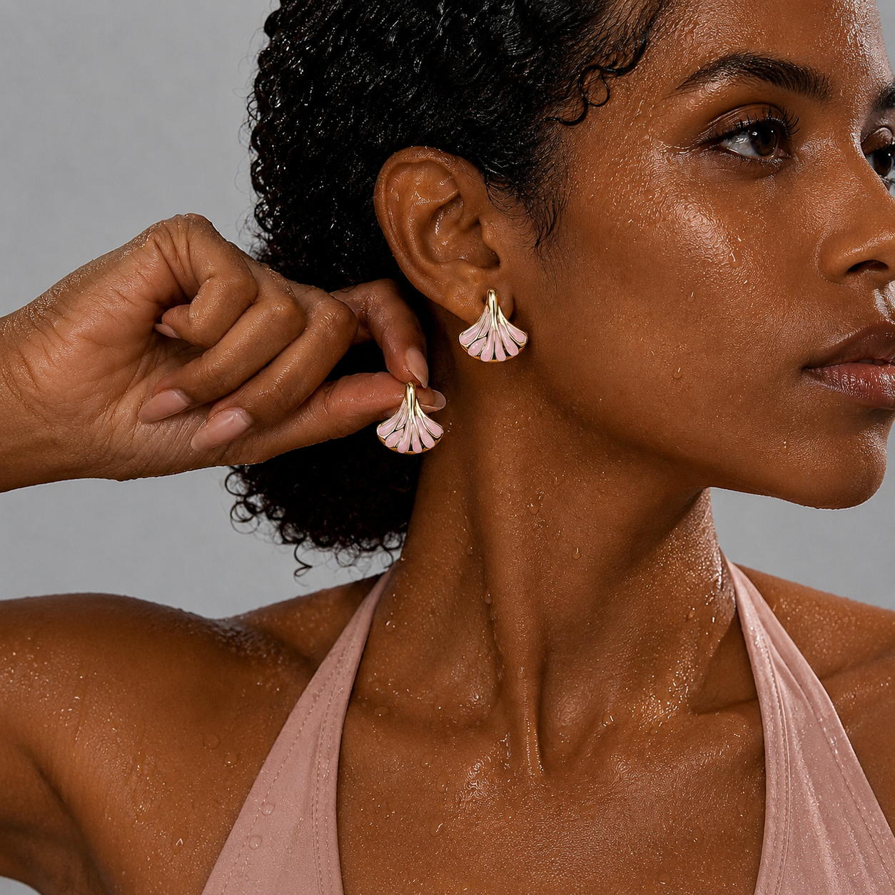Maris Studs blush pink enamel shell stud earrings with gold fan detail worn by wet model – hypoallergenic waterproof non-tarnish stainless steel stud earrings