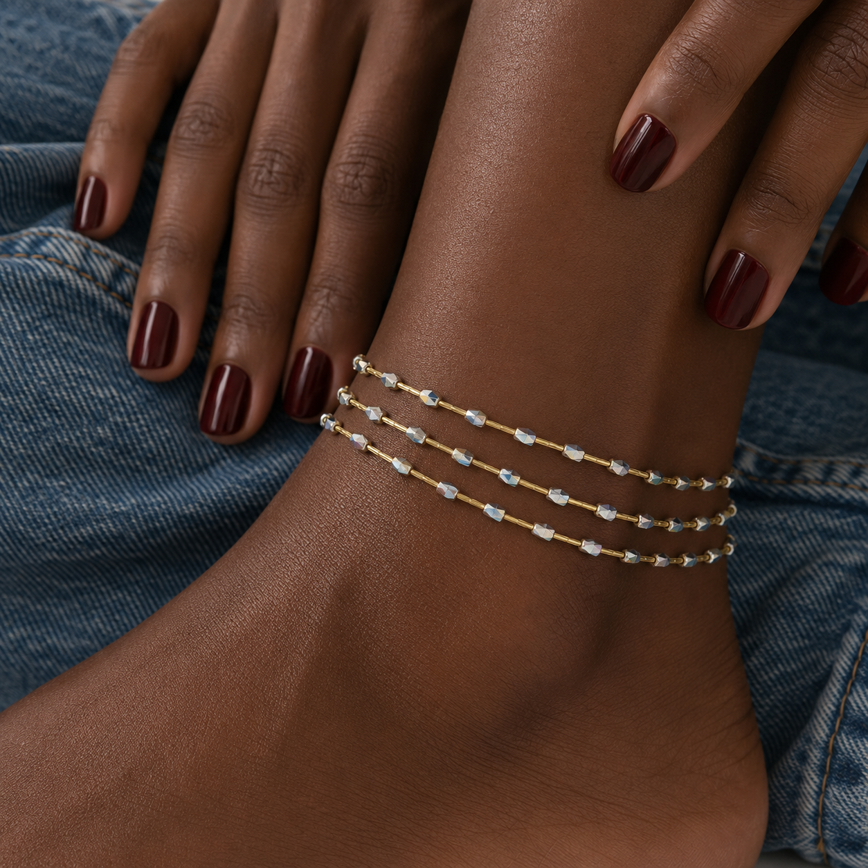 Model wearing Neri Anklets in iridescent silver – beaded anklets, delicate anklets, crystal anklets layered like a set on dark skin