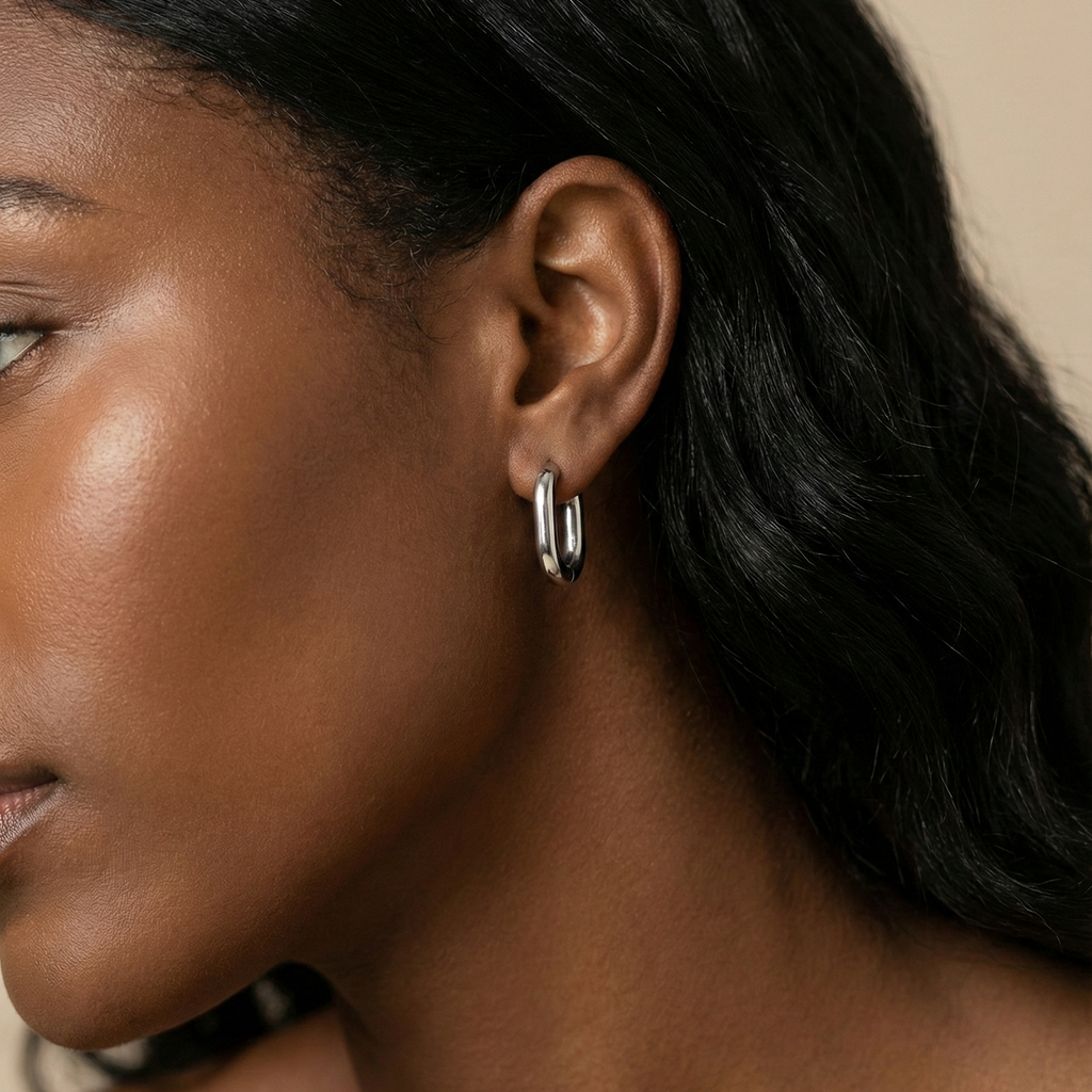 Nné Hoops silver huggie hoop earrings with sleek round silhouette worn by model – minimalist hypoallergenic stainless steel small hoop earrings for sensitive ears