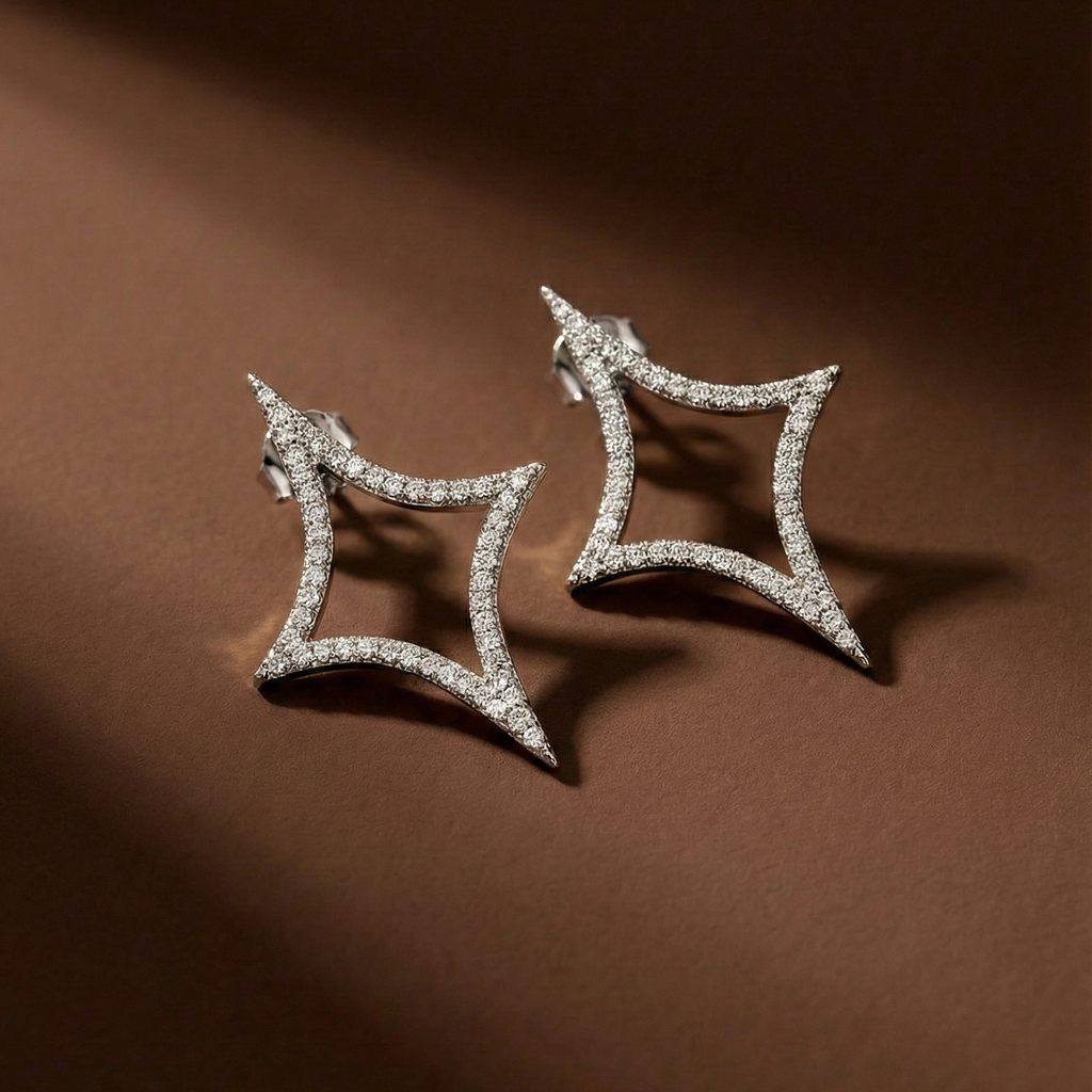 Nova Studs silver pavé star stud earrings flat lay on rich brown background – sparkle emoji cubic zirconia earrings in waterproof surgical steel for sensitive ears
