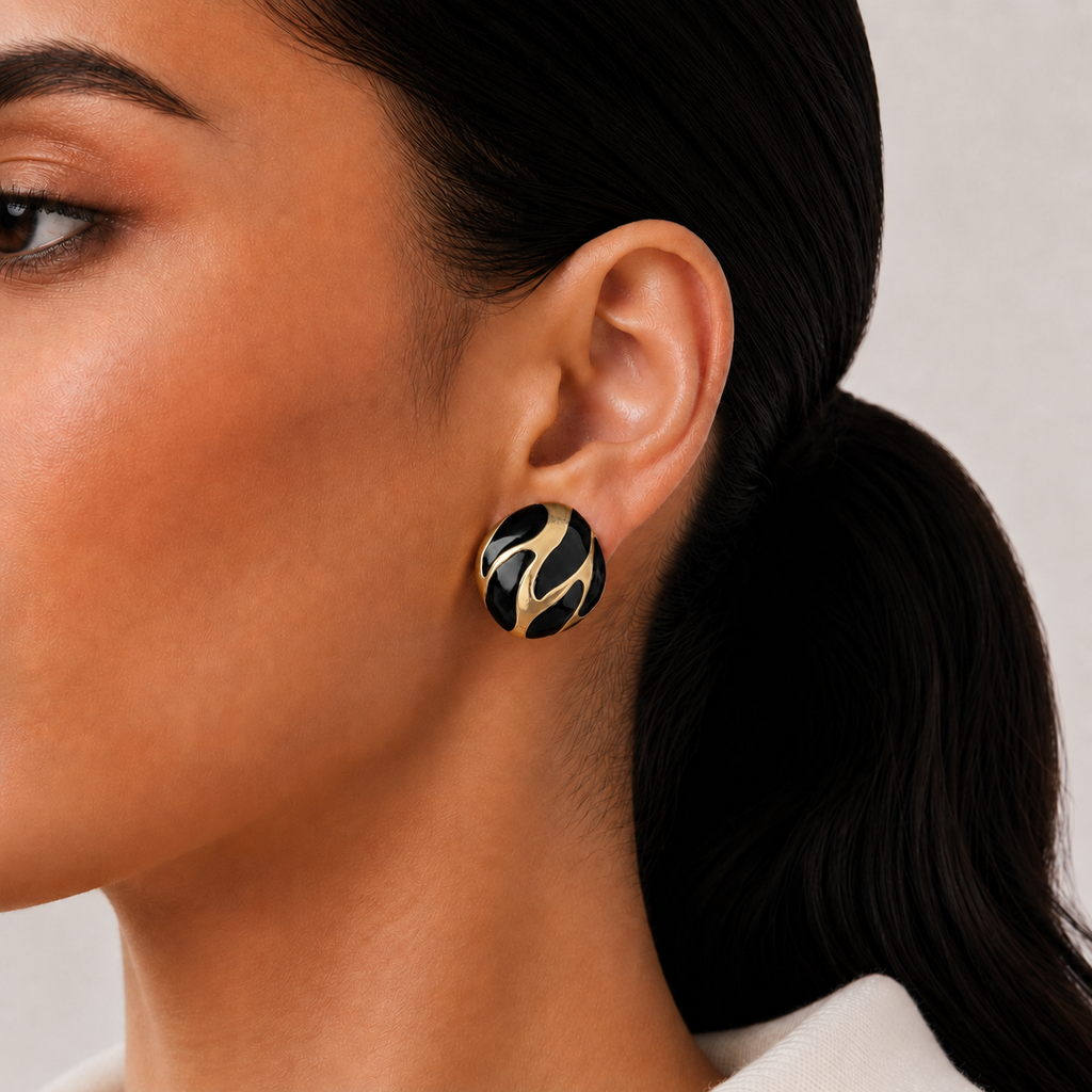 Riva Studs black and gold enamel swirl oval stud earrings with bold wave detail – hypoallergenic nickel-free stainless steel non-tarnish everyday earringsstyled on a lightskinned model 