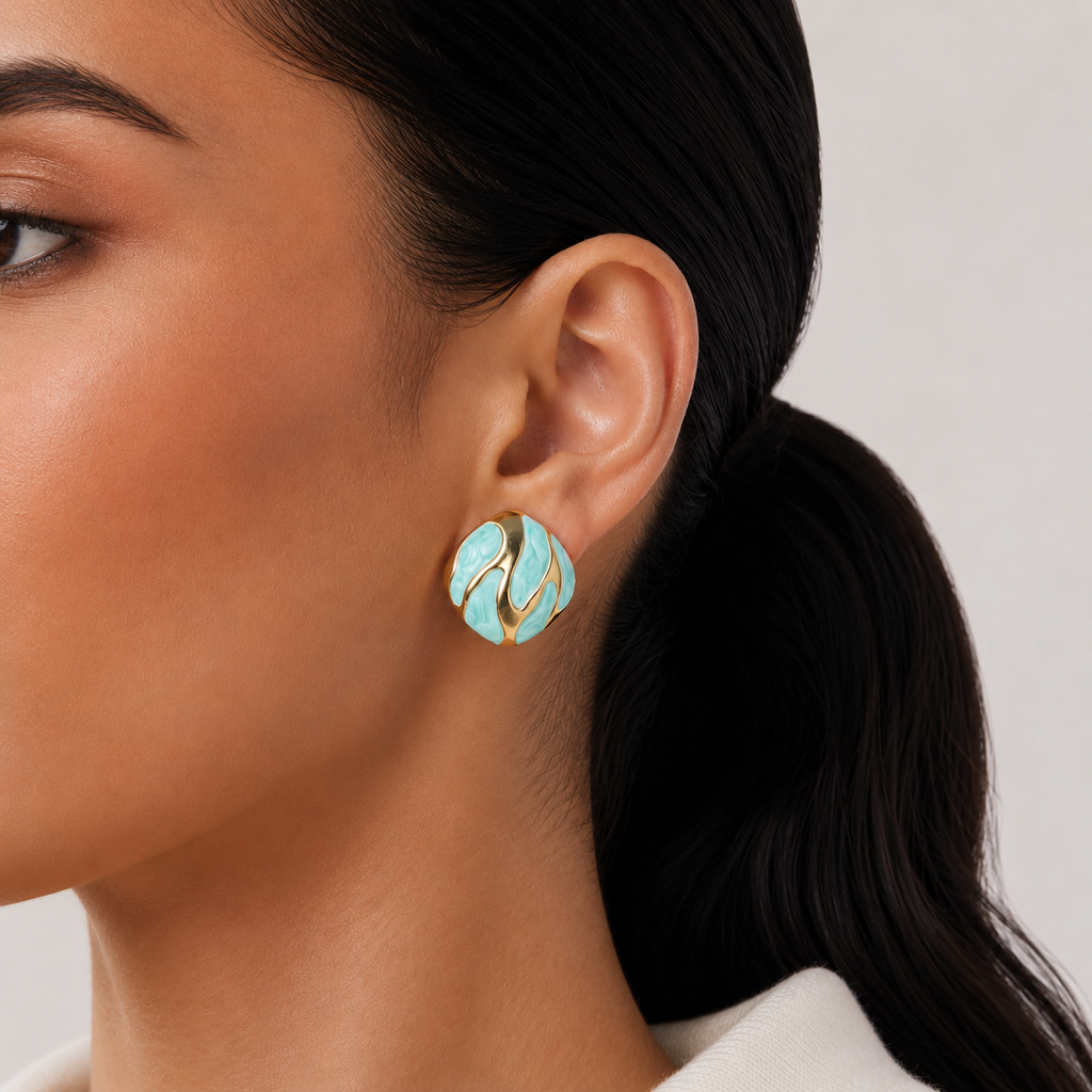Riva Studs mint green and gold enamel swirl oval stud earrings with bold wave detail – hypoallergenic nickel-free stainless steel non-tarnish earrings for sensitive ears styled on a lightskinned model 
