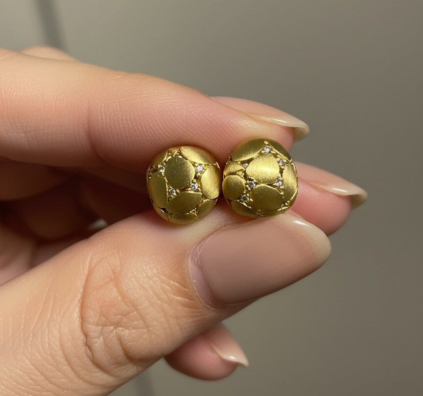 Wendy Studs brushed matte gold dome stud earrings with quilted texture and crystal detail held between fingers – hypoallergenic non-tarnish waterproof stainless steel brushed gold earrings