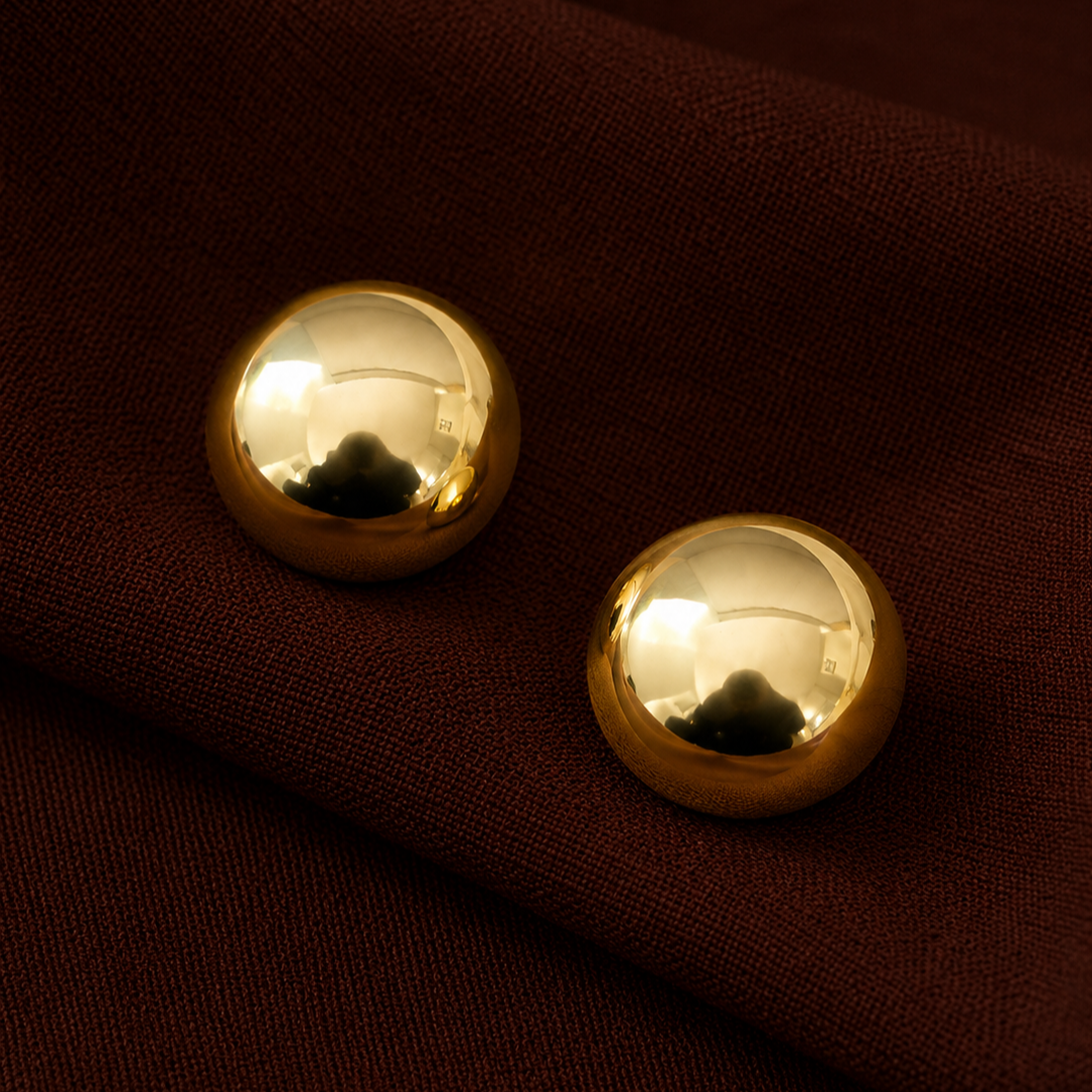 Xena Studs gold polished stainless steel dome stud earrings on deep burgundy linen fabric – hypoallergenic gold and silver earrings, tarnish free and waterproof for everyday wear