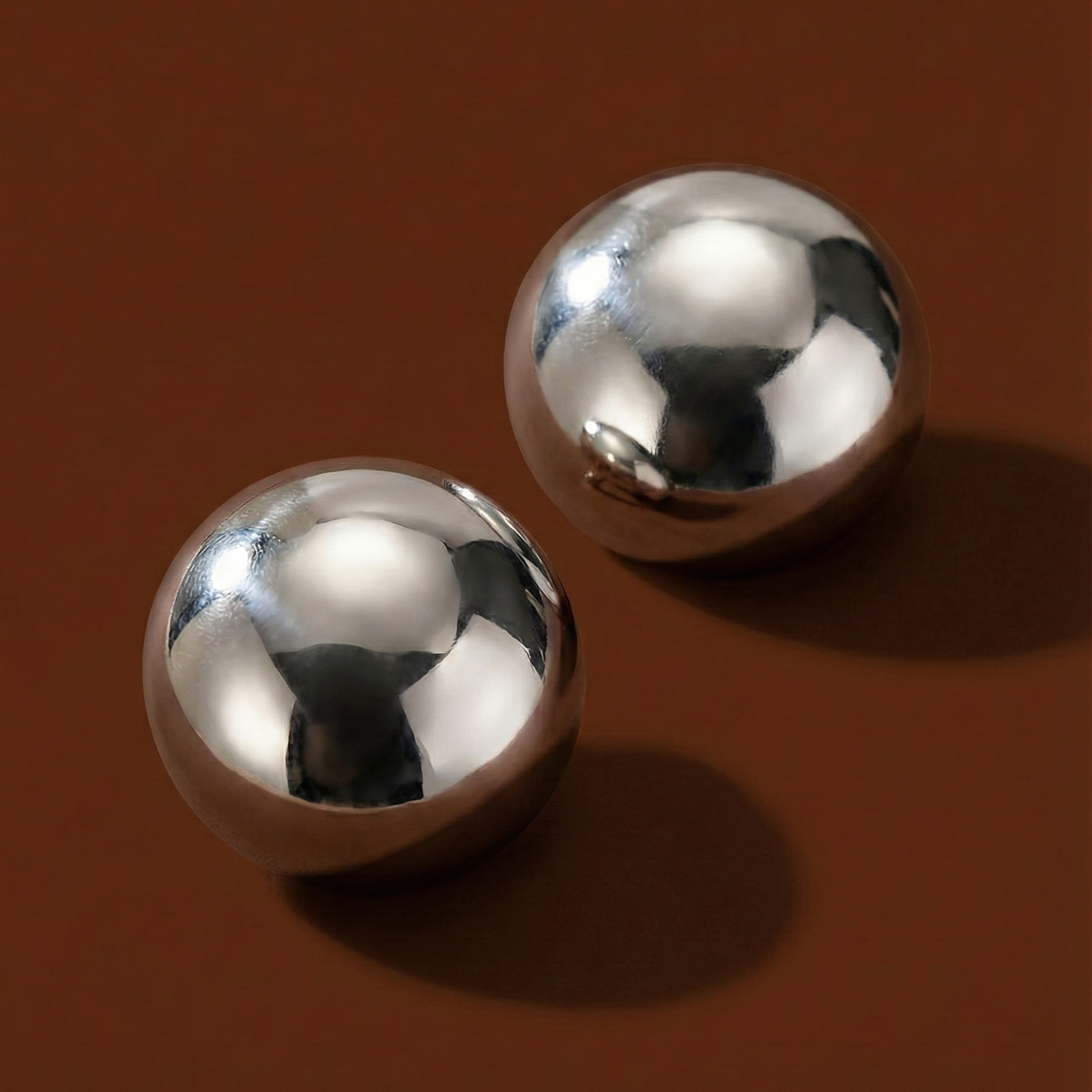 Xena Studs silver polished stainless steel stud earrings shown on cream background – hypoallergenic dome stud earrings, tarnish free and waterproof for everyday wear