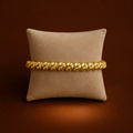 Zena Bracelet gold twisted rope bangle on cushion display – bold classic stretch bangle, non-tarnish waterproof hypoallergenic stainless steel women's bracelet UK jewellery