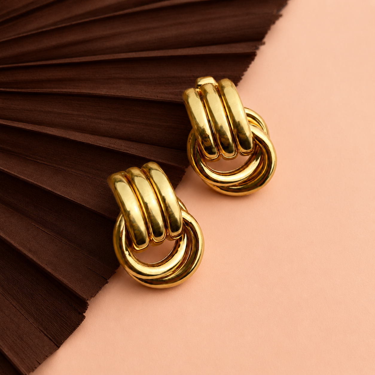 Zia Earrings gold door knocker earrings on peach background – statement stud earrings, gold stud earrings, stainless steel earrings, non tarnish earrings, waterproof earrings