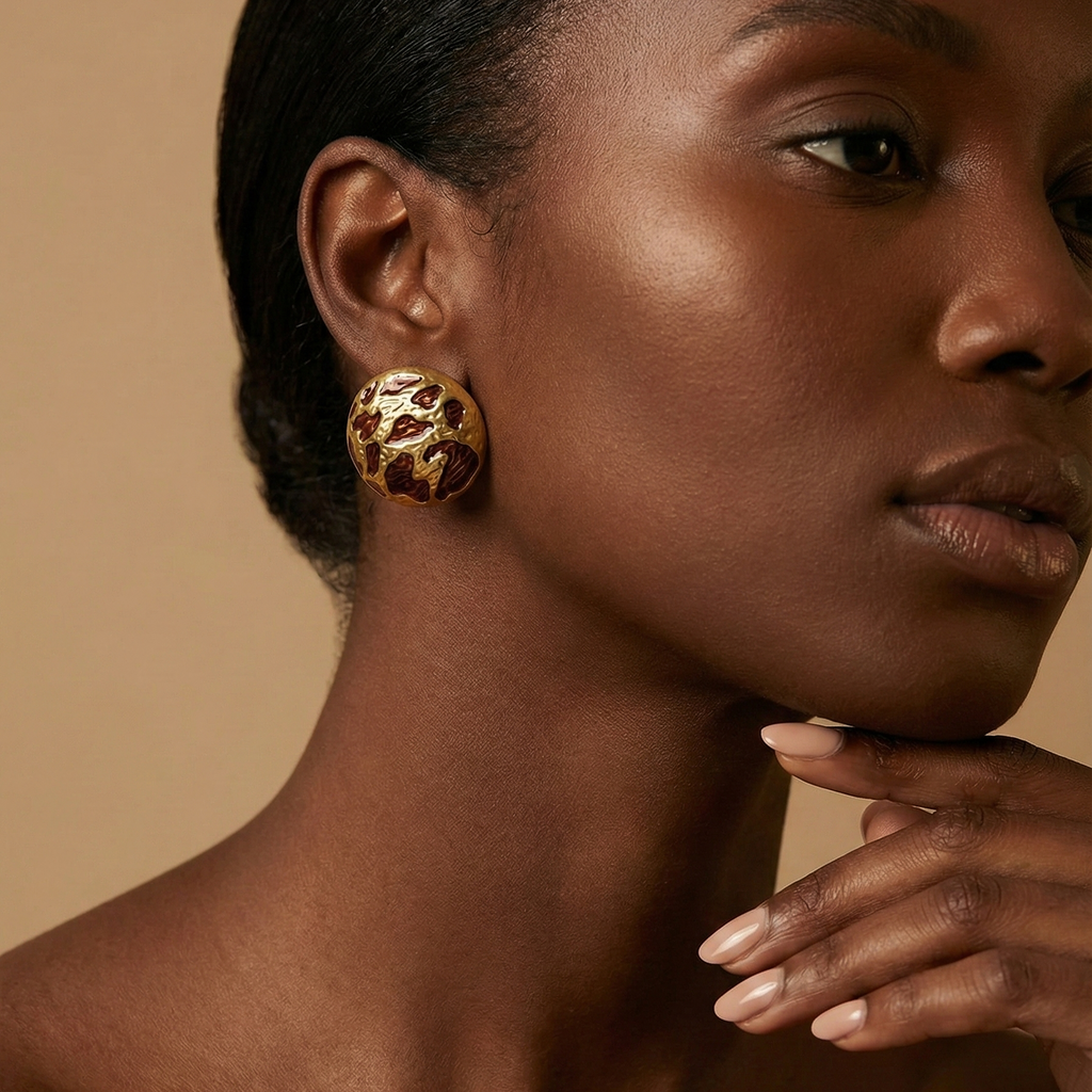 Zola Studs gold leopard print dome stud earrings worn on ear in editorial profile portrait – tarnish free waterproof stainless steel animal print earrings for sensitive ears