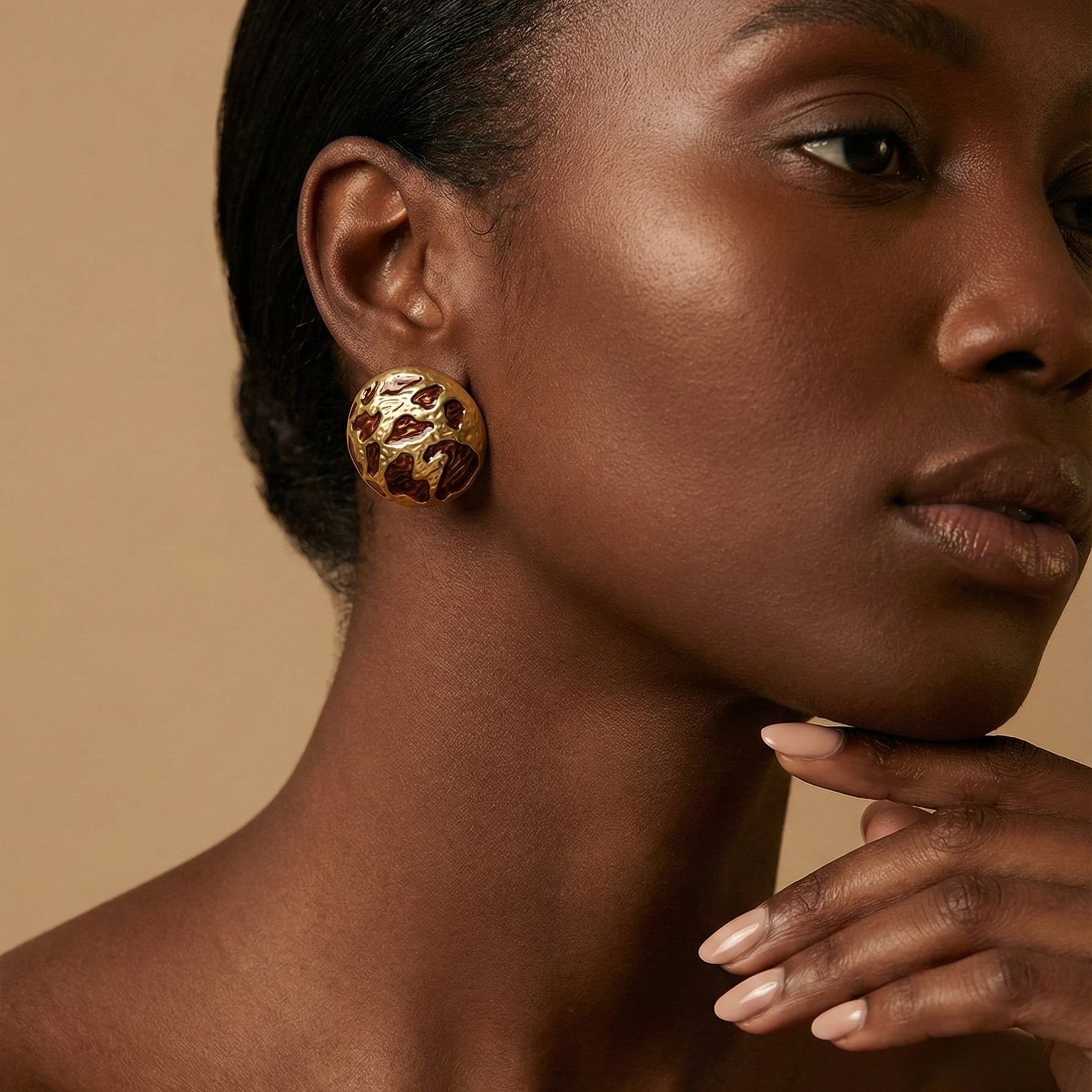 Zola Studs gold leopard print dome stud earrings worn on ear in editorial profile portrait – tarnish free waterproof stainless steel animal print earrings for sensitive ears