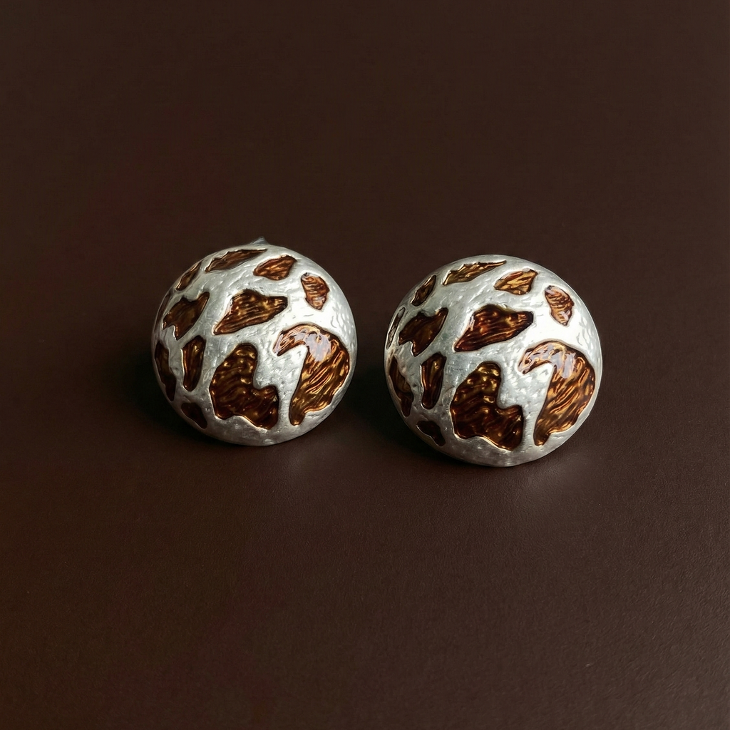 Zola Studs silver leopard print dome stud earrings flat lay on deep brown background – waterproof tarnish free stainless steel animal print earrings for sensitive ears