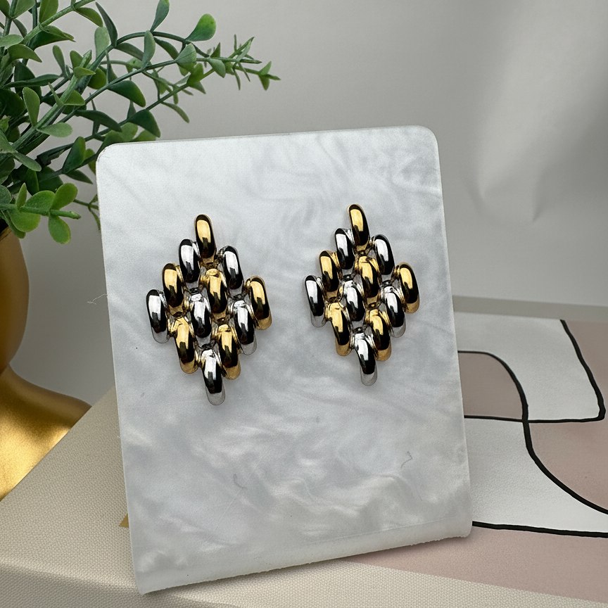 Zuri Studs two tone gold and silver geometric lattice earrings displayed on white marble stand with greenery – mixed metal cluster stud earrings that don't tarnish stainless steel